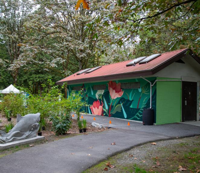 Fieldhouse studio at Lions Park with colourful painted mural and greenery surrounding