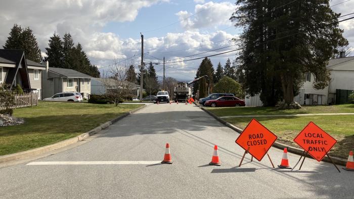 Road with traffic cones and signage indicating road closure.