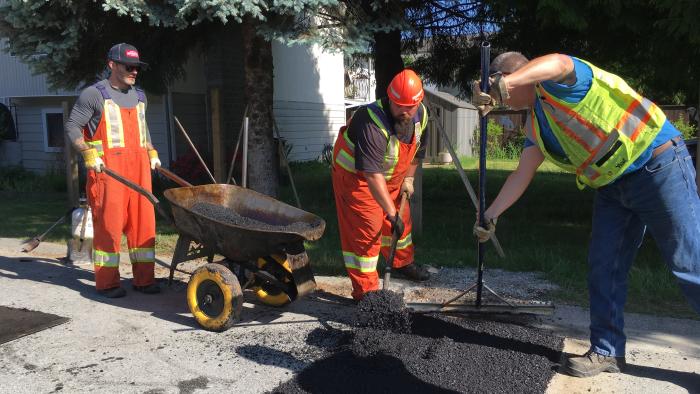 Construction workers paving a road.