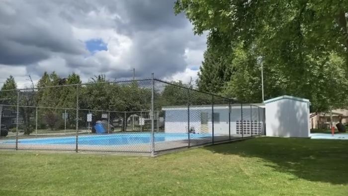 Outdoor pool surrounded by chainlink fence.