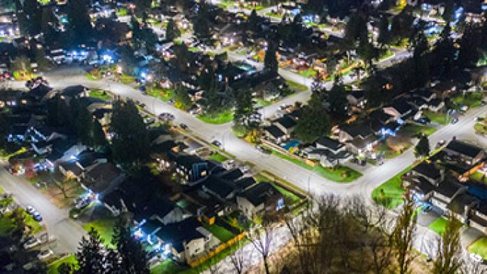 Night time aerial view of Port Coquitlam. The city is illuminated with streetlights.