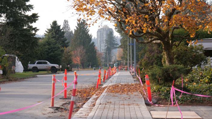 Construction cones and tape surrounding sidewalks.