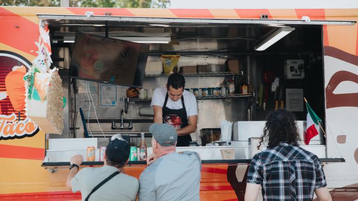 People gathered around a taco food truck