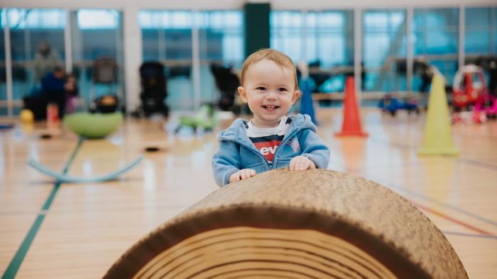 Child smiling playing with a toy in gymnasium