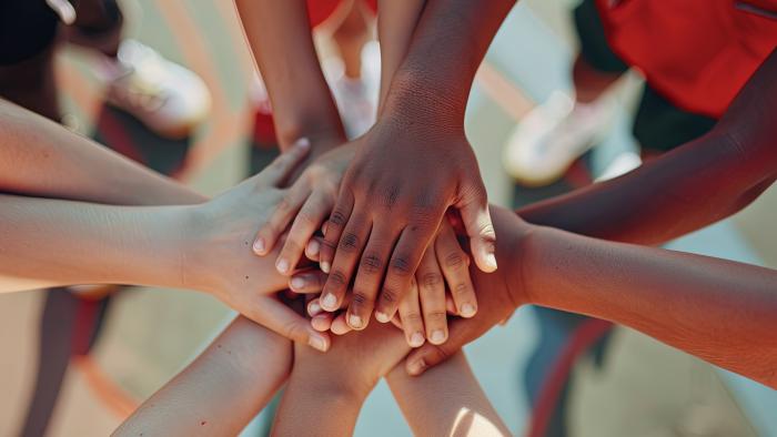 Team with hands in on sports courts