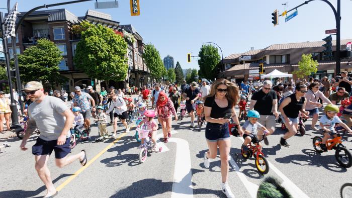 Crowd participating in a bike race for kids in downtown Port Coquitlam