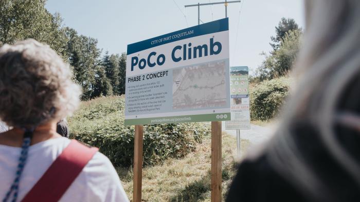 People standing in front a sign at outdoor PoCo Climb trail