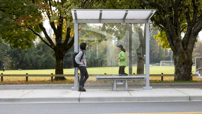 Person waiting for bus at transit shelter