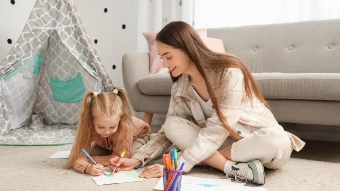 Youth babysitting colouring with a child