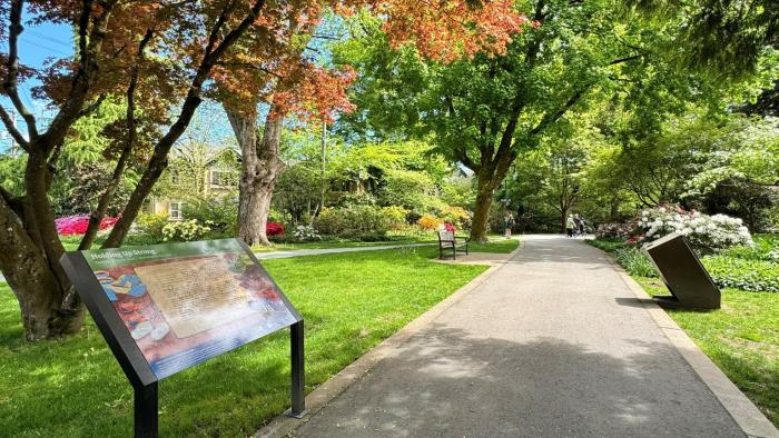Donald Storywalk pathway with a panel and trees and flowers