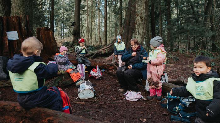Kids participating in recreation program sitting outside in the forest