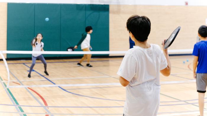 kids playing pickleball in gymnasium