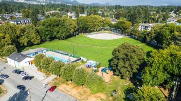Aerial view of Aggie Park featuring grass field, outdoor pool, and baseball diamond