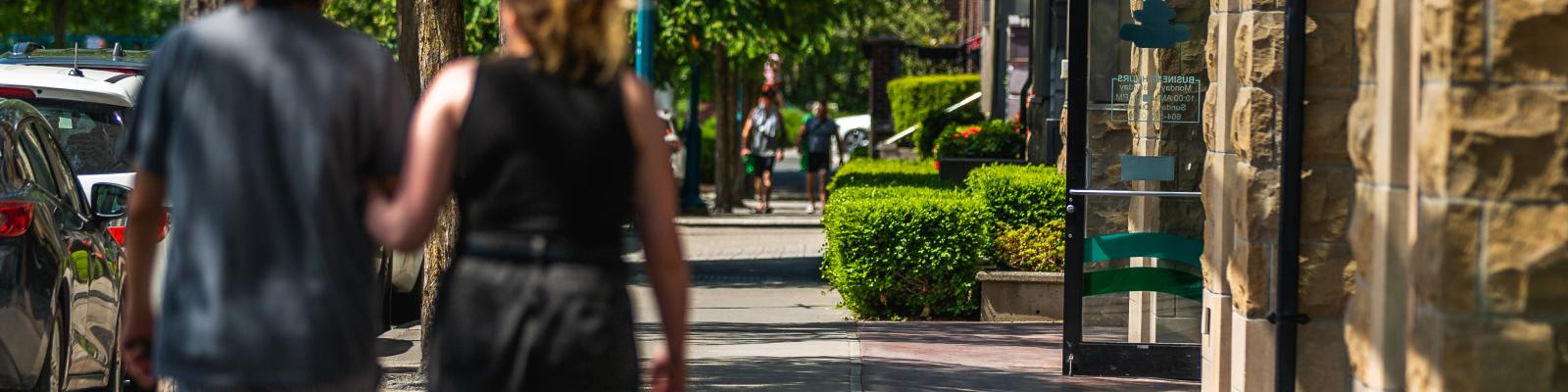 Two people walking through business area in Port Coquitlam
