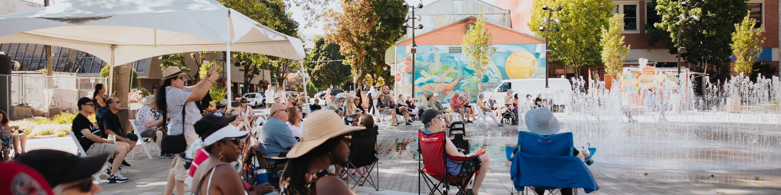 people in Leigh Square on chairs in sunshine
