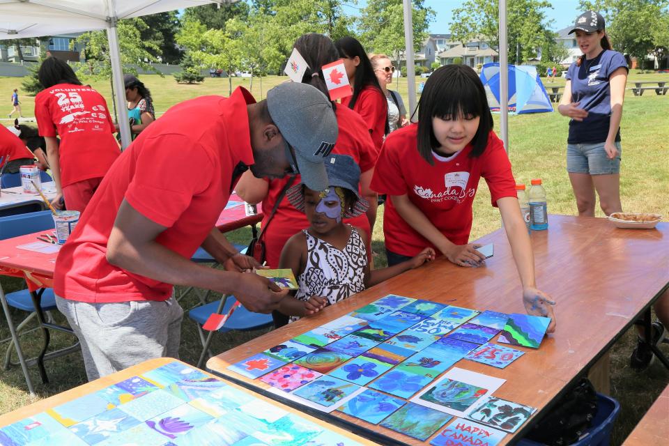 People working on a community mural wall