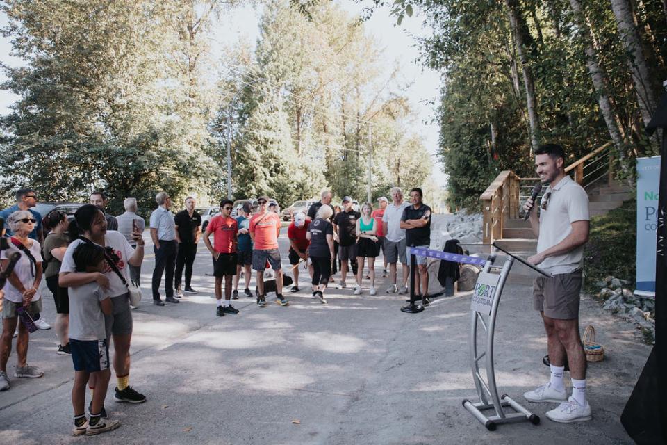 Group of people gathered listening to a speech. The people are on a nature trail.