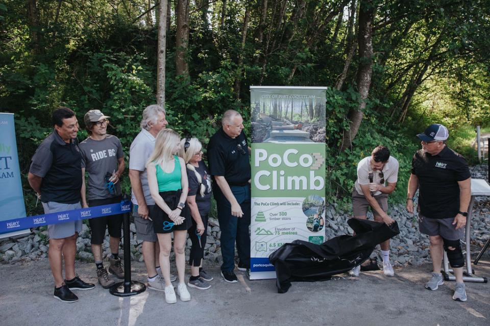 Group of people unveiling PoCo Climb sign.