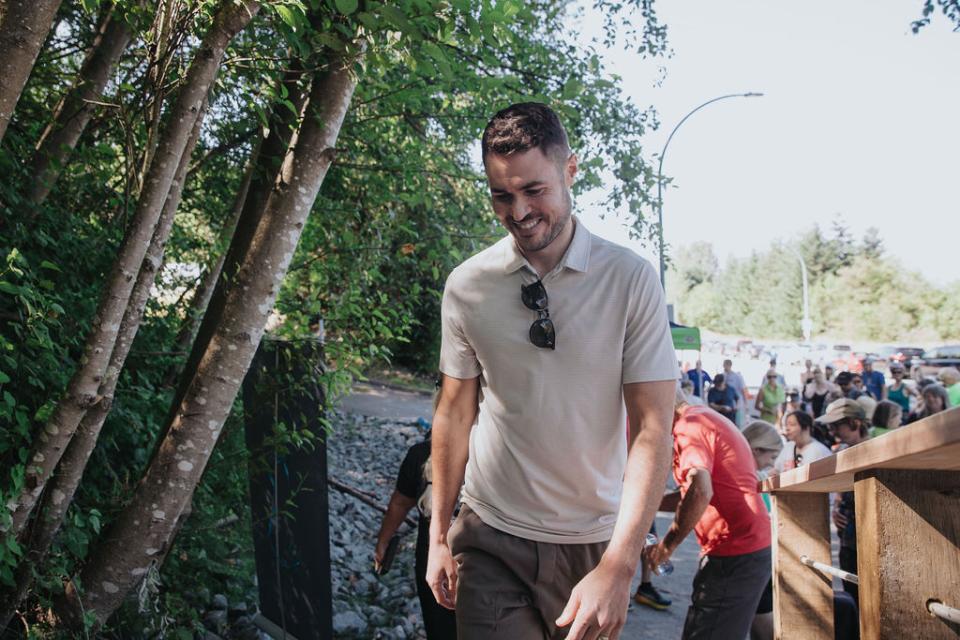 Smiling man walking through trail path.
