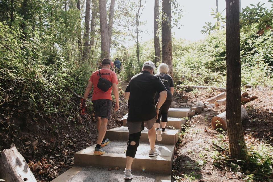 Group of hikers using concrete steps on a hiking trail.