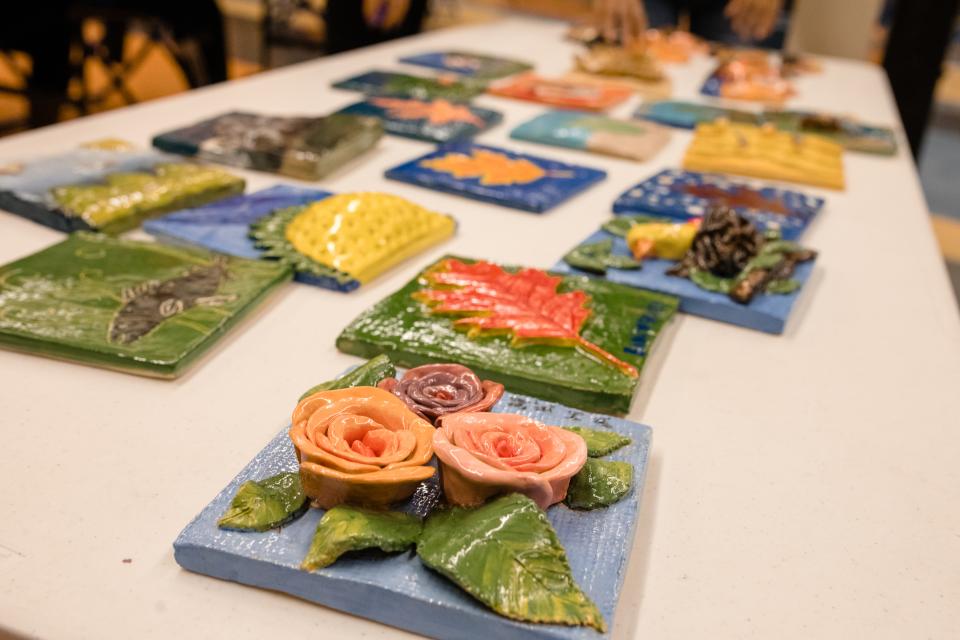 Clay tiles that have been painted showing 3 dimensional roses