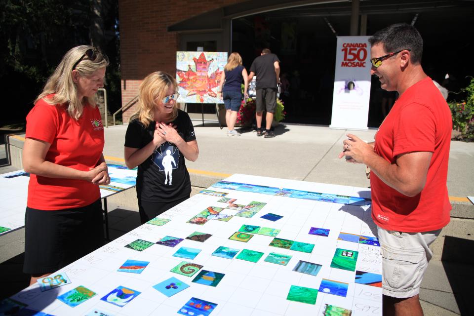 People working on a community mural wall