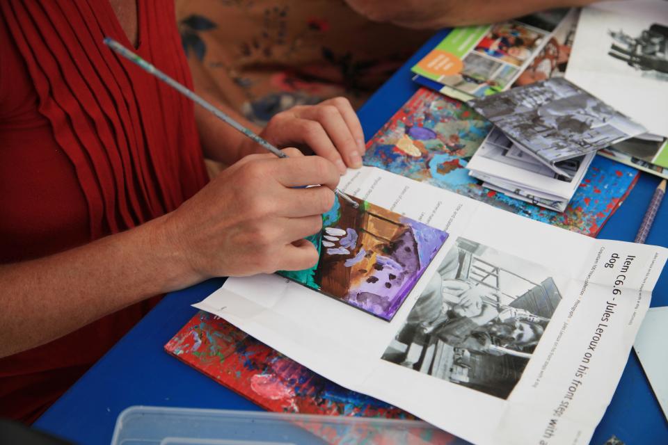 People working on a community mural wall