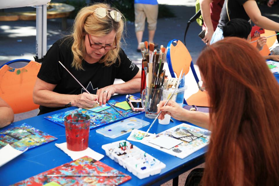 People working on a community mural wall