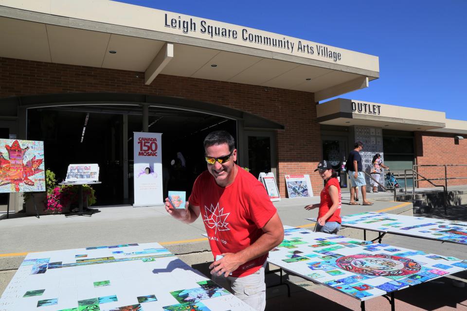 People working on a community mural wall