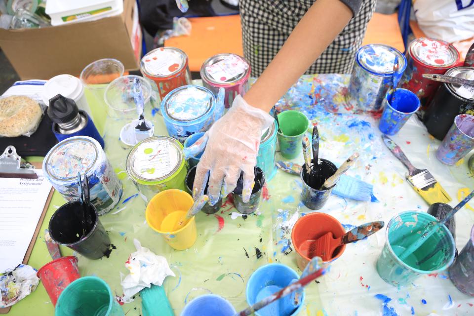 A bunch of open paint cans on a table