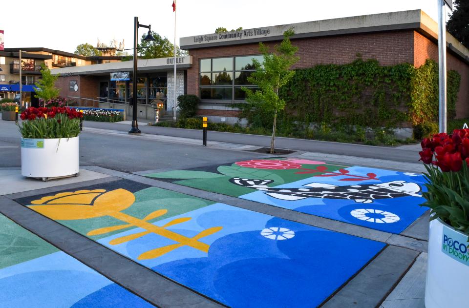 A sidewalk mural featuring various coloured flowers