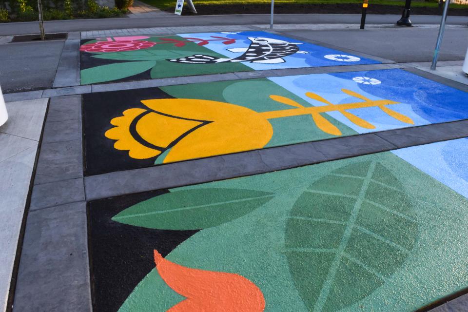 A sidewalk mural featuring various coloured flowers