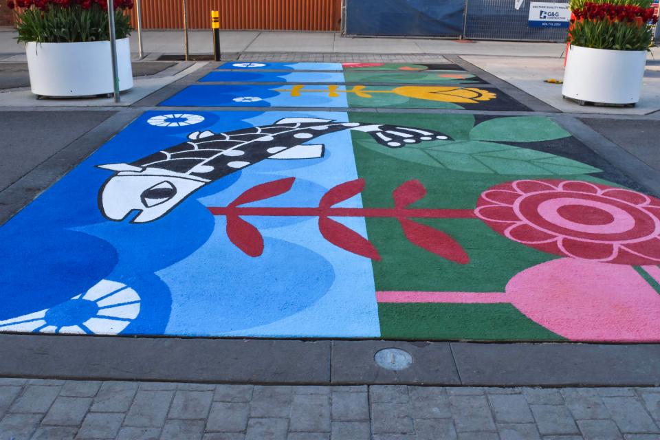 A sidewalk mural featuring various coloured flowers