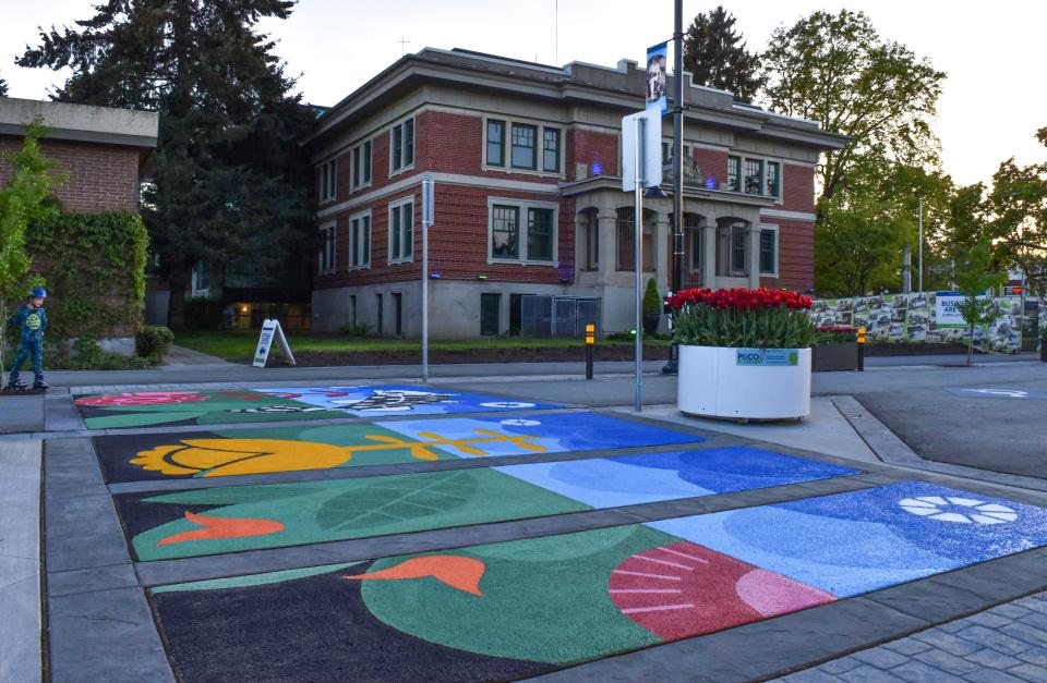 A sidewalk mural featuring various coloured flowers