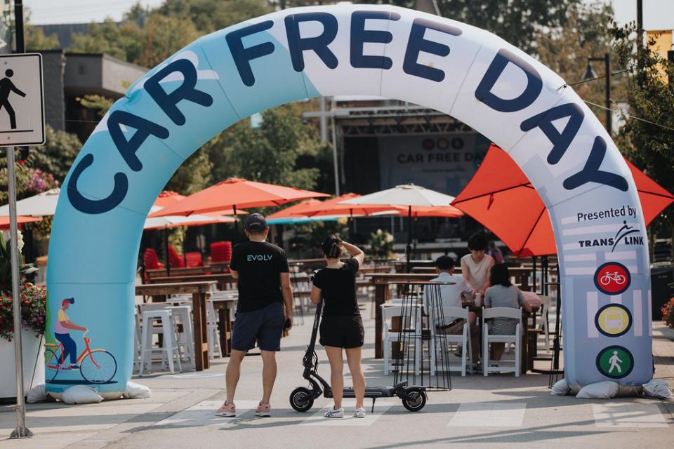 People standing in front of arch that reads "Car Free Day."