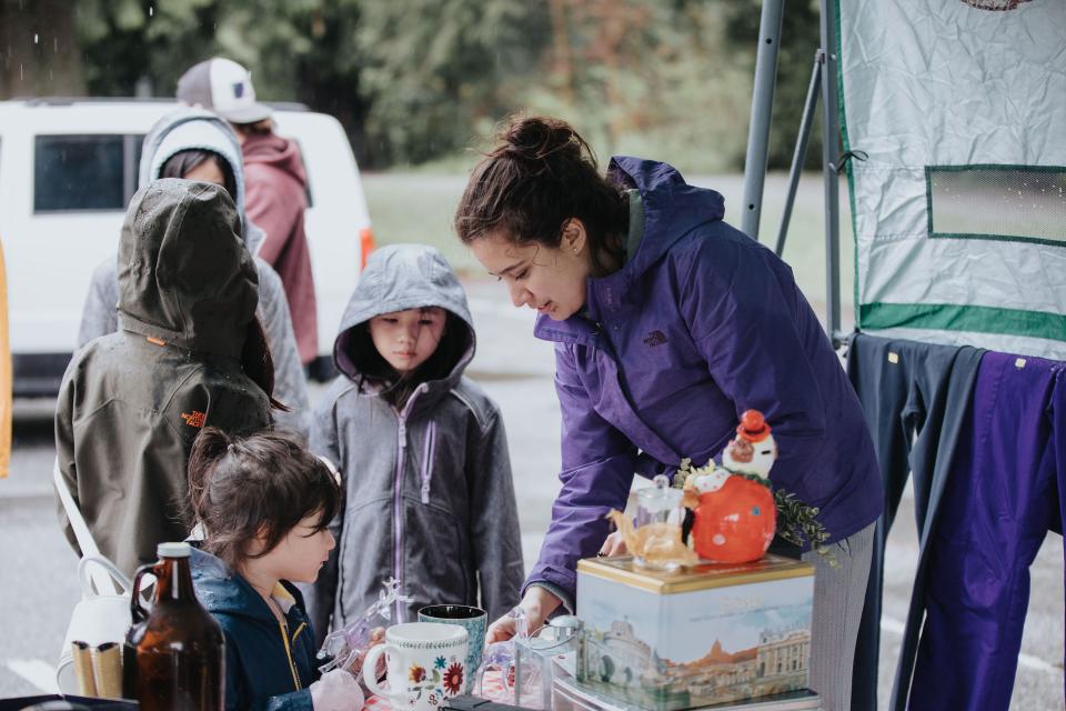 Garage sale shoppers and sellers at a booth