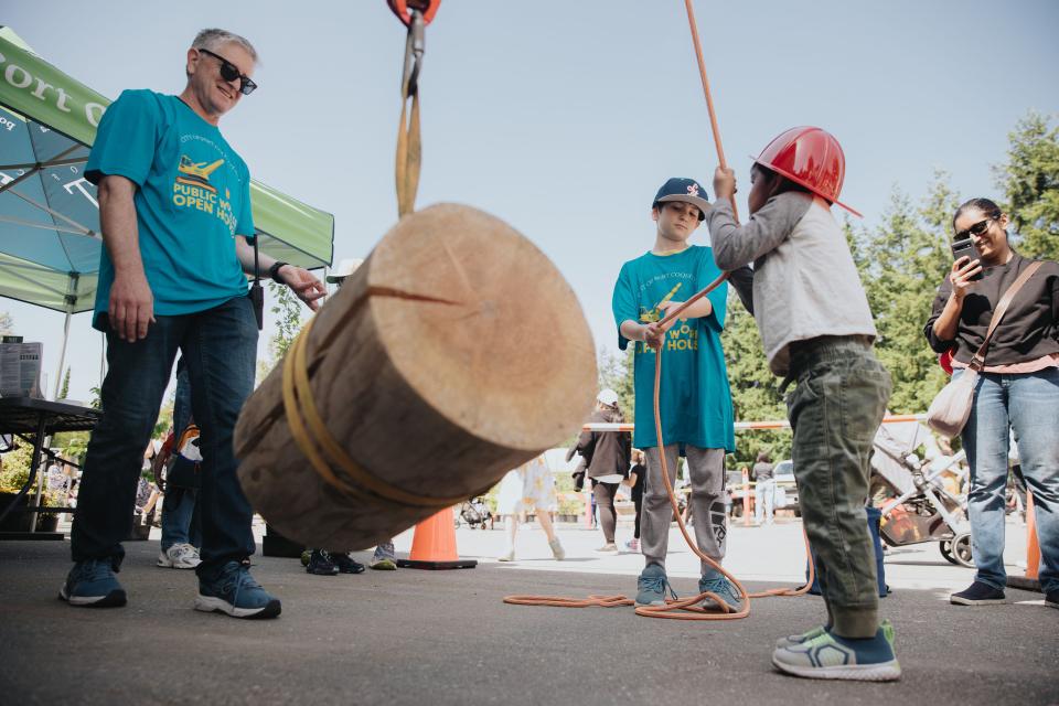 Kids using pulley to lift wood at Public Works Open House