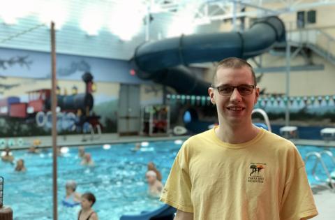 A man standing in front of a public swimming pool