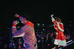Two performers signing to crowd from the CPKC Holiday Train platform