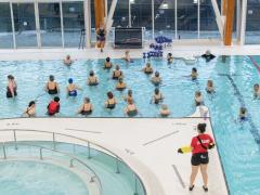 Indoor pool at PCCC with people in the water and lifeguard on deck