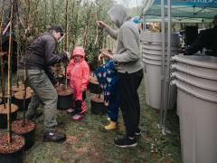 Family picking up a free tree at Earth Day celebration