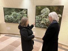 Two people standing in front of two pieces in art gallery