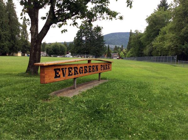 Signage for Evergreen Park. The sign is wooden with dark lettering.