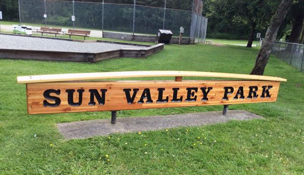 Sun Valley Park sign. The sign is wooden with dark lettering.