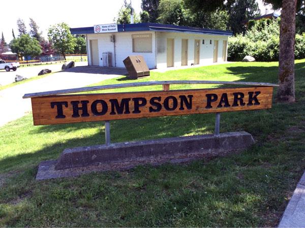 Thompson Park sign. The sign is wooden with dark lettering.