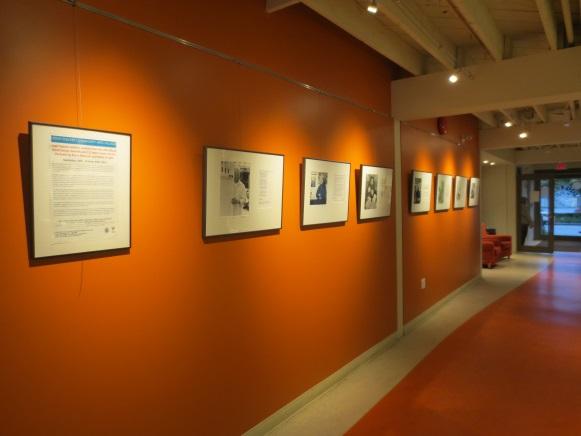 Orange art gallery wall with artwork on them.