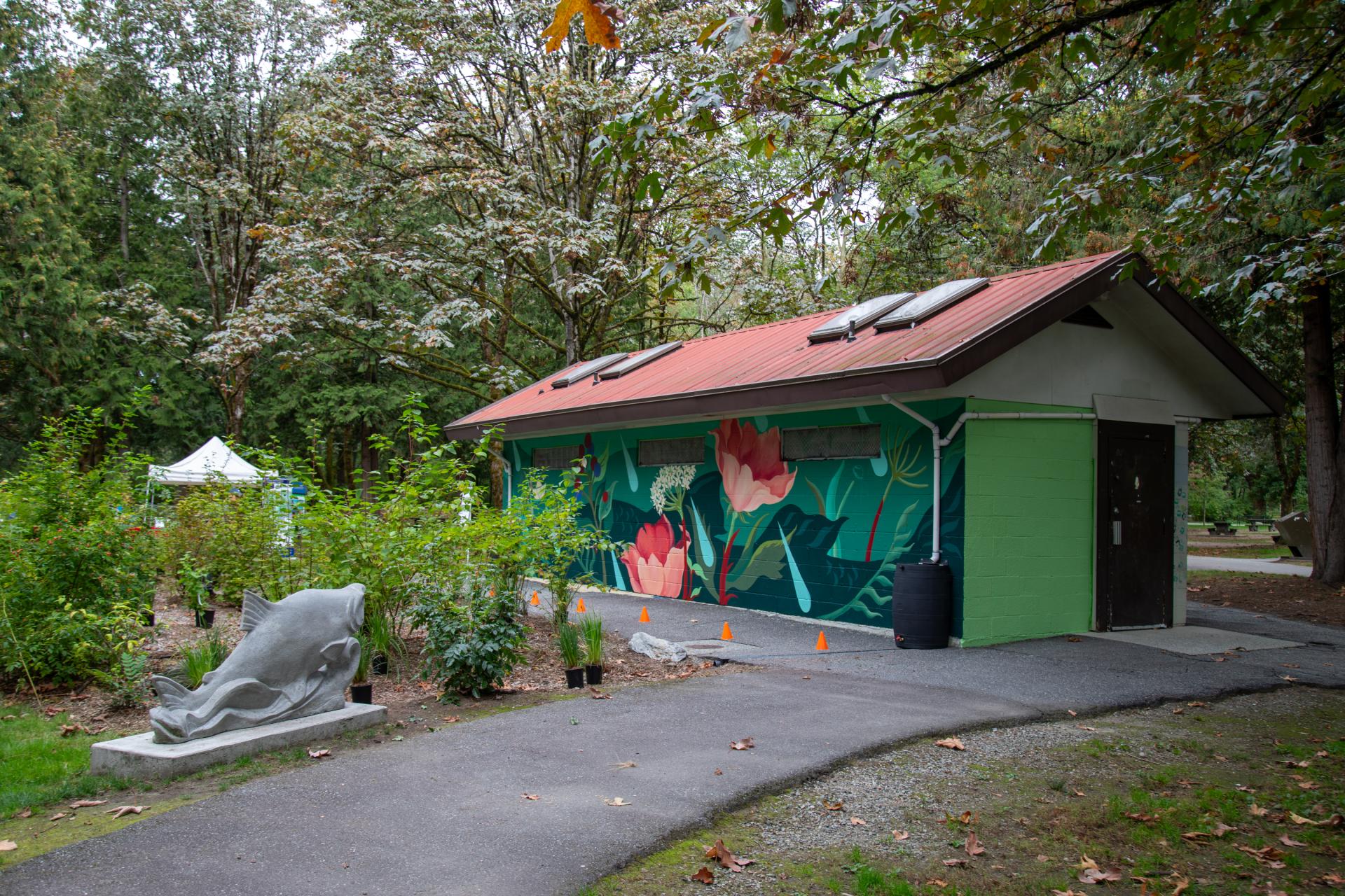 Fieldhouse studio at Lions Park with colourful painted mural and greenery surrounding