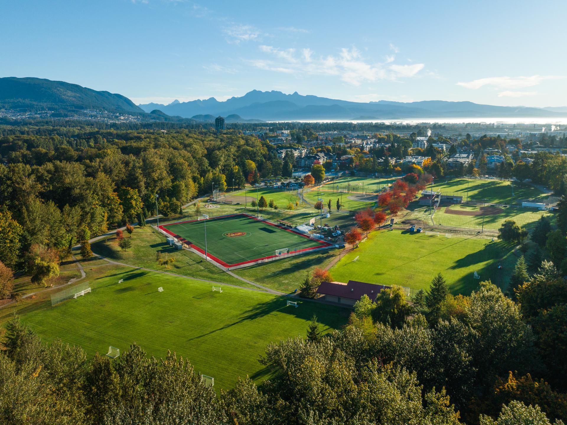 Aerial view of Gates Park showing green spaces, sports fields, mountains and trees