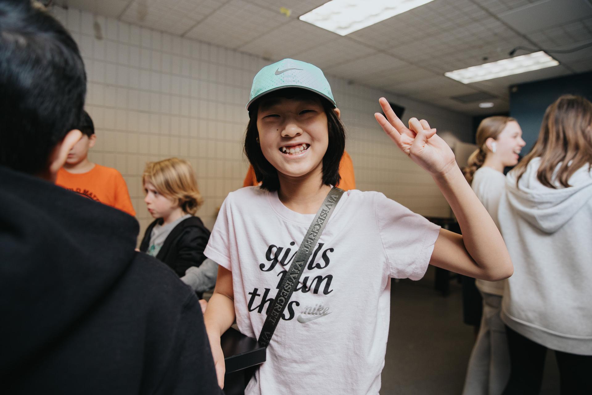 Youth at youth centre holding a peace sign in the air