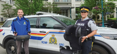 Police officers standing in front of a police car, holding car seats